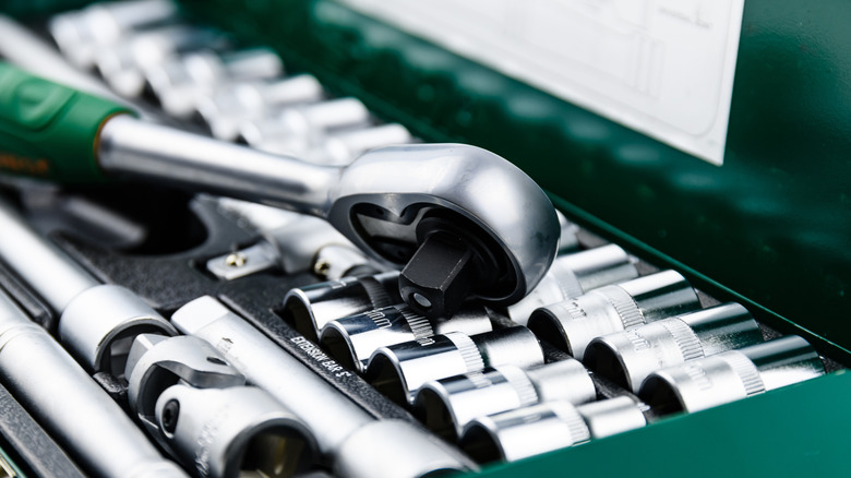A socket wrench laying across a socket set.