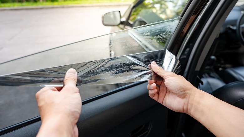 Person removing car window tint