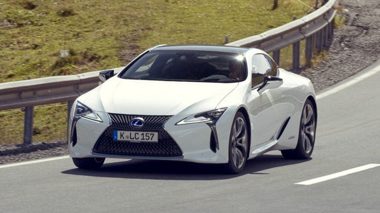 A white Lexus LC500 coupe driving on the road.