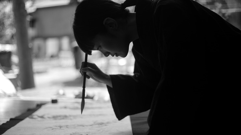 Japanese woman doing caligraphy outside