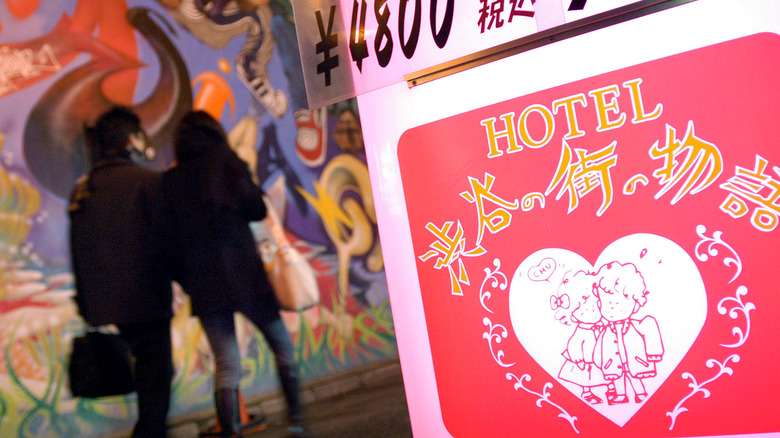 Couple walk past love hotel