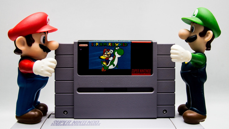 Mario and Luigi holding a SNES cartridge