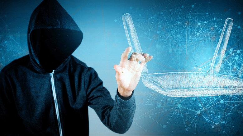 A man in a hood with his face obscured next to a hand-drawn router