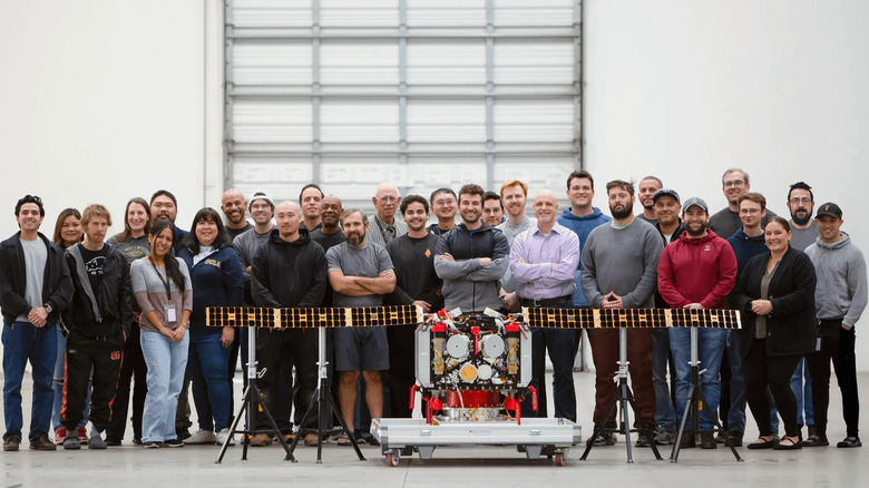 The AstroForge team stands behind its spacecraft, Odin