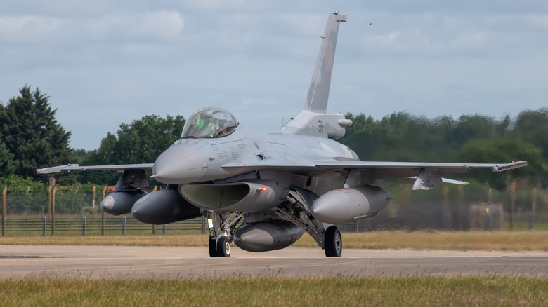Grey fighter jet on the runway taxing.