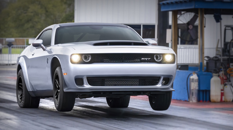 Dodge SRT Demon 170 popping a wheelie as it accelerates down a drag strip