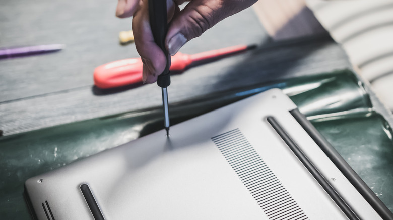 unscrewing the backplate of a laptop