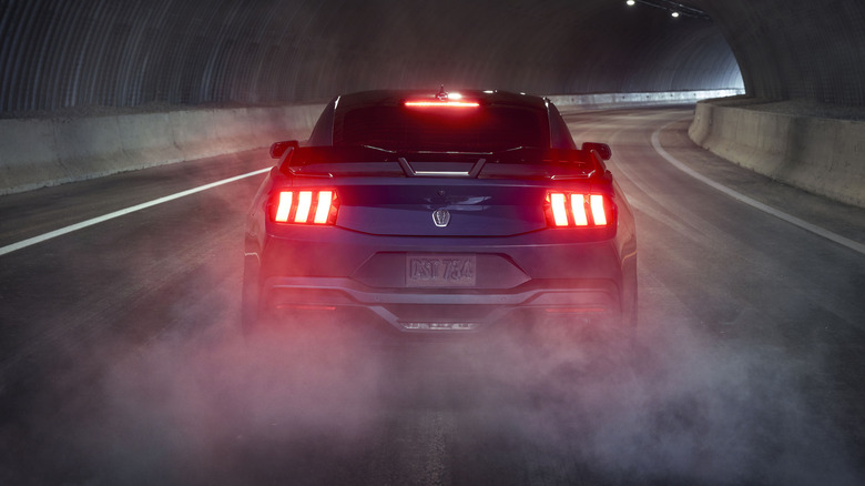 Rear view of Ford Mustang Dark Horse doing burnout in tunnel.