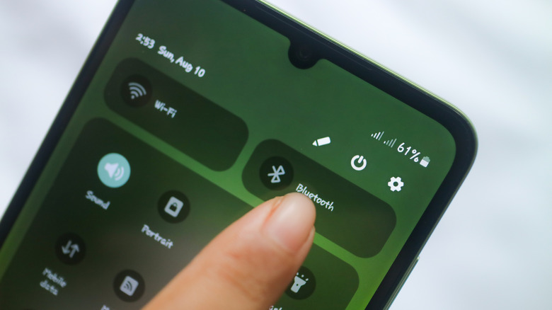 Person tapping Bluetooth Icon on phone