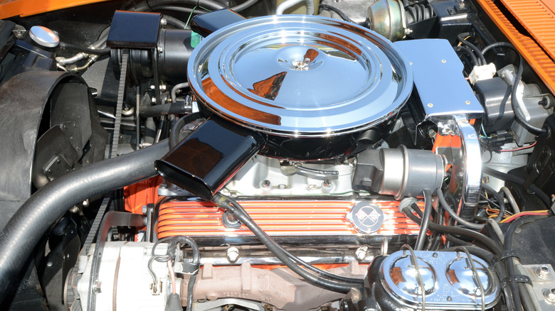 A Chevy 350 V8 finished in chrome and orange paint in an engine bay