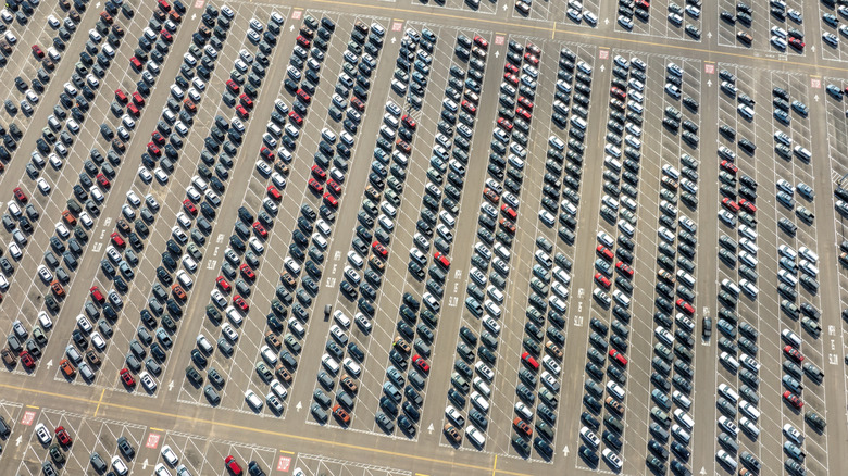 Aerial view of new vehicles awaiting shipment in storage lot.