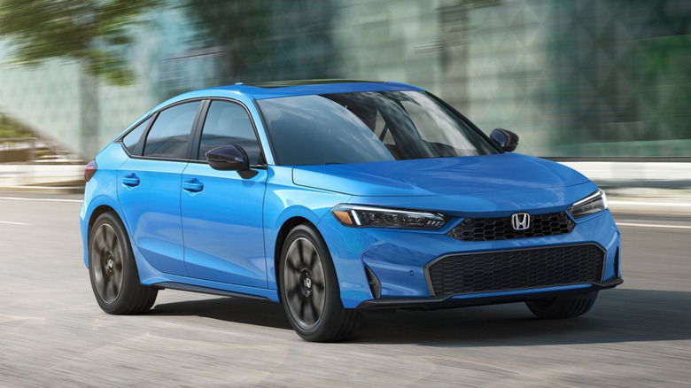 Honda Civic hatchback driving down a road