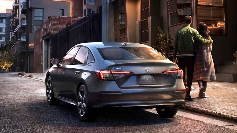 Couple standing next to a Honda Civic