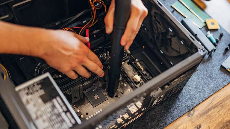 person vacuuming a PC