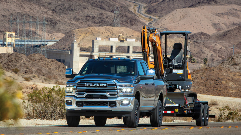 Gray Ram 2500 towing a digger on a trailer