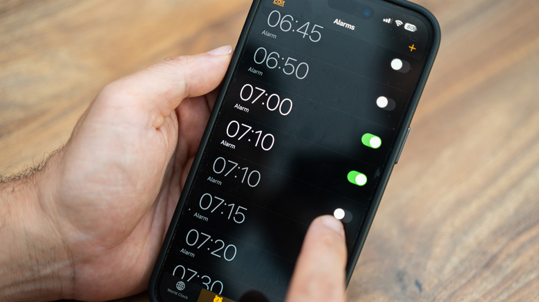 person setting iPhone alarms