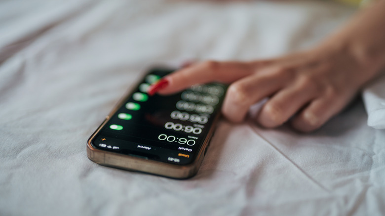 person turning on iPhone alarms