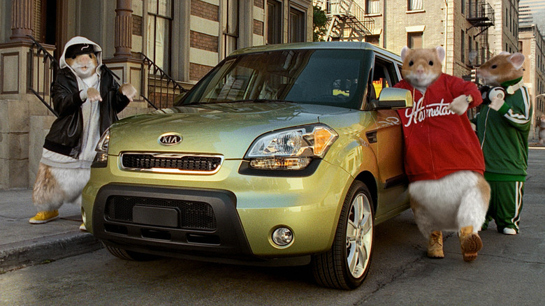 Kia Soul parked in city with hamsters standing near it