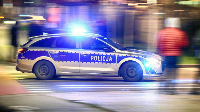 Polish police car in chase at night through the city with motion blur