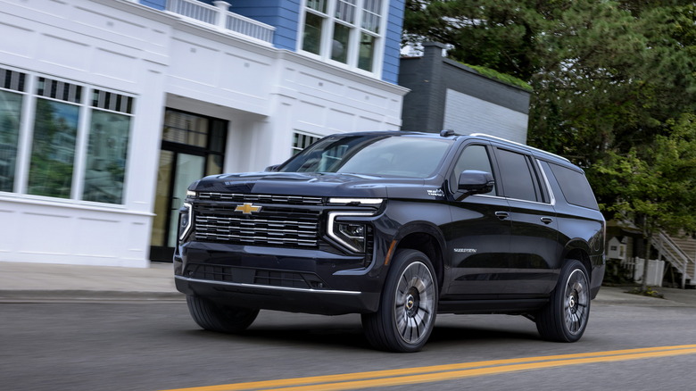 A black 2025 Suburban High Country driving on the road