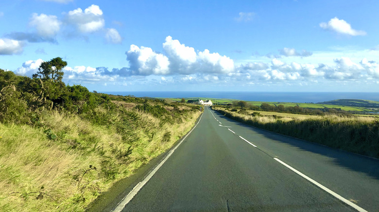 Part of the Isle of Man TT Mountain Course, two-lane straight road on partly-cloudy day