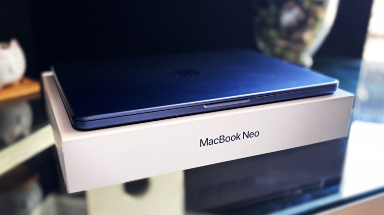 MacBook Neo tertutup di atas kotak produk