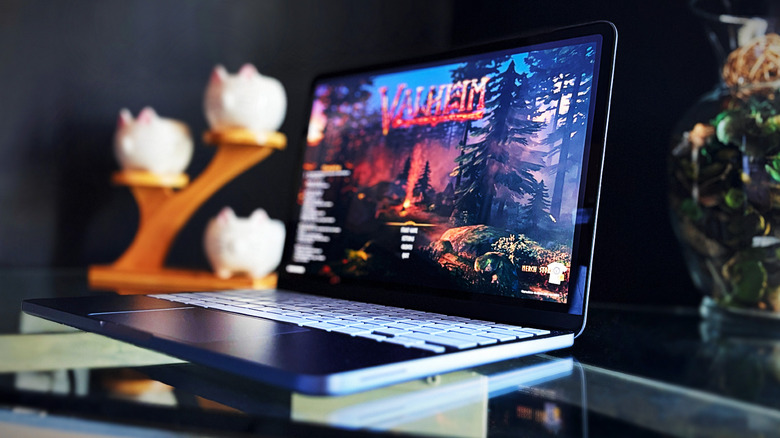 Tampilan sudut MacBook Neo dengan permainan "Valheim" di layar