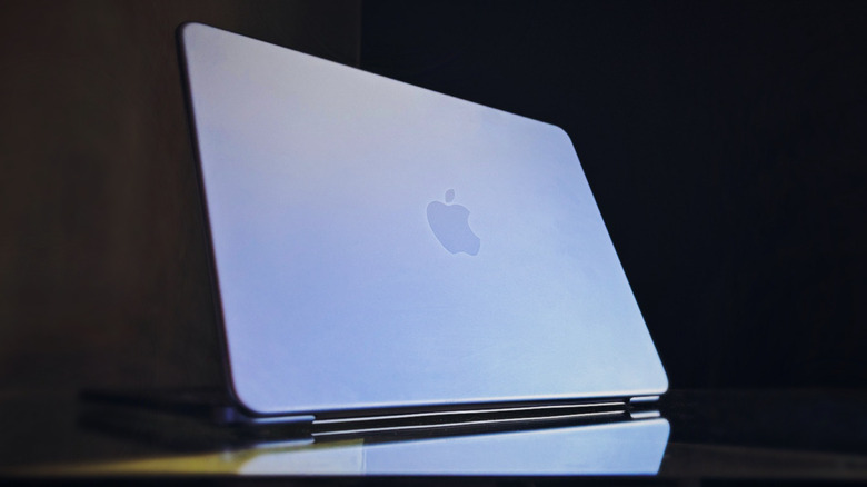 Foto miring di bagian belakang tutup MacBook Neo dengan logo Apple terlihat