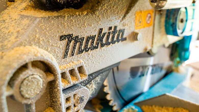 makita power saw covered in wood dust