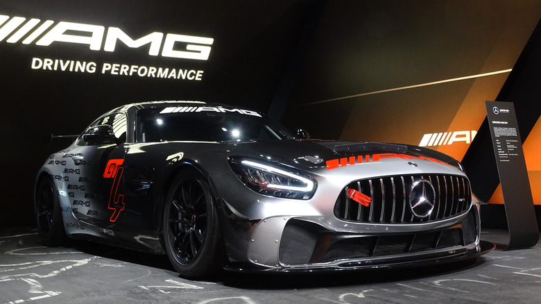 A Mercedes-AMG GT4 on display at an AMG stand, front 3/4 view