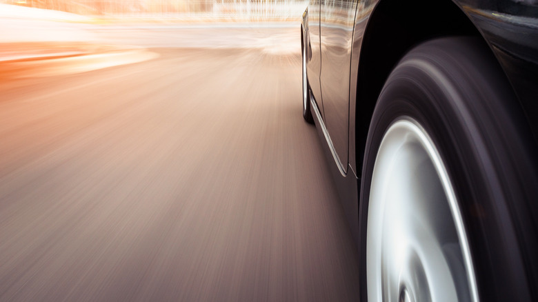 A tire and wheel rotating on a car in motion