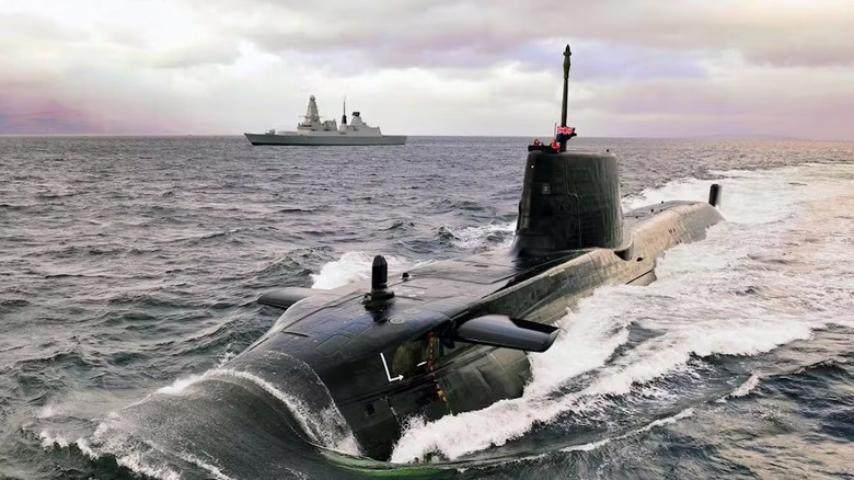 An Astute-class submarine cruising on the water surface with another ship in the background.