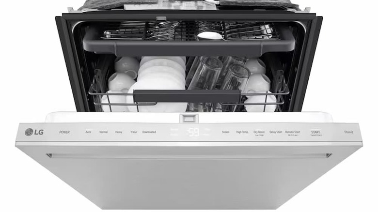 An open LG dishwasher with dishes inside and a visible front control panel.