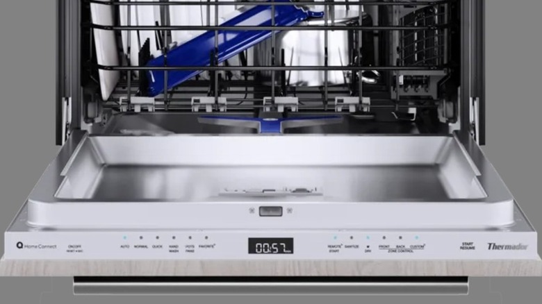 An open Thermador dishwasher filled with dishes.