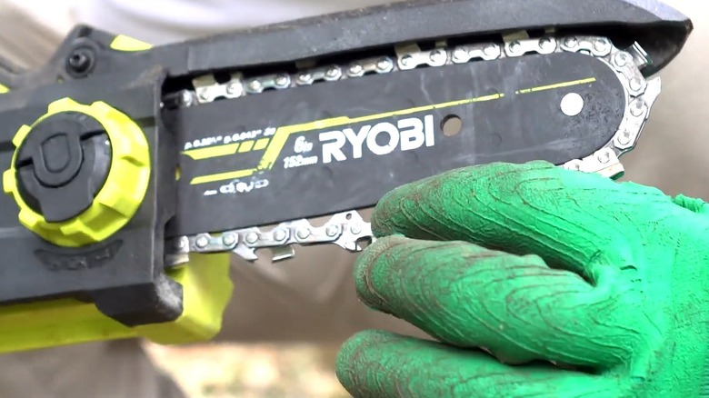 A person demonstrating a loose chain on the ONE+ 18V 6-inch Cordless Battery Compact Pruning Mini Chainsaw