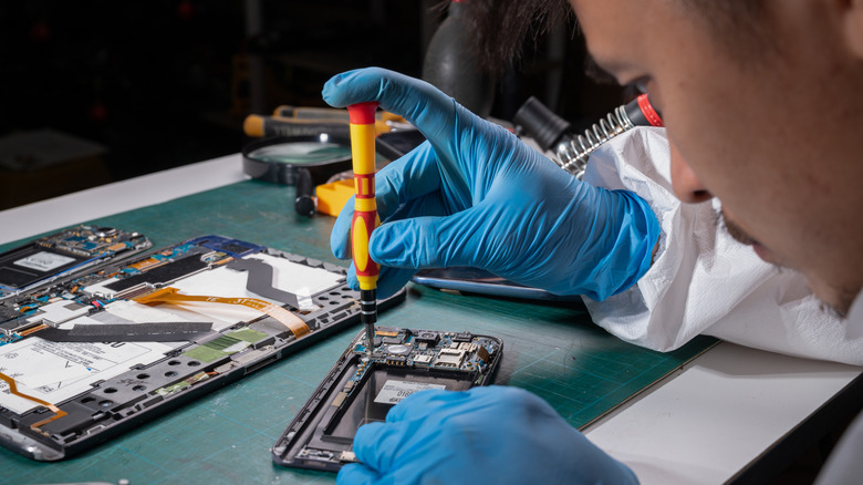 person repairing a disassembled device