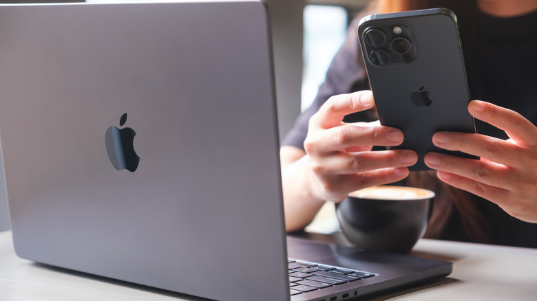 person using iPhone 15  and MacBook