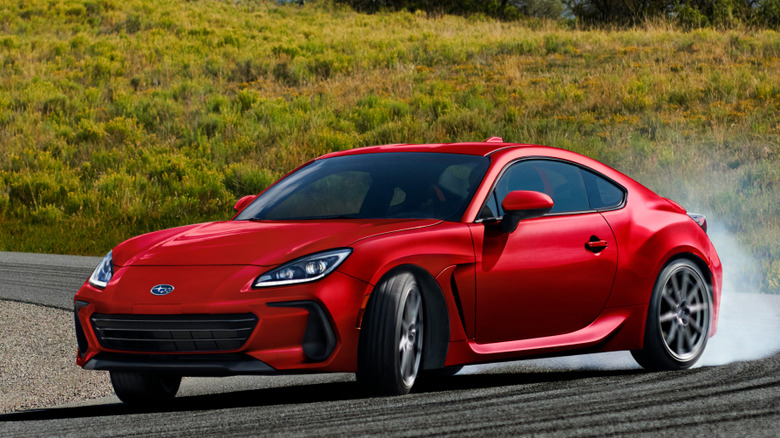 Front 3/4 view of 2027 Subaru BRZ sliding around a sharp turn in the road in a mountainous setting