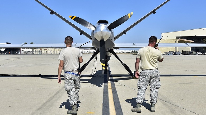 Two Air National Guard members standing by an MQ-9 Reaper