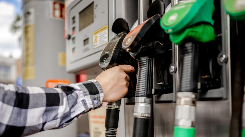 Man's Hand Taking Gas Pump For Car Refueling At Gas Station