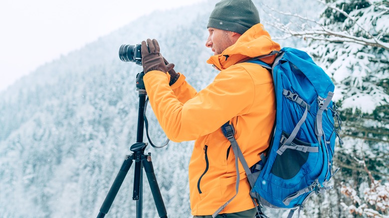 man using camera on tripod