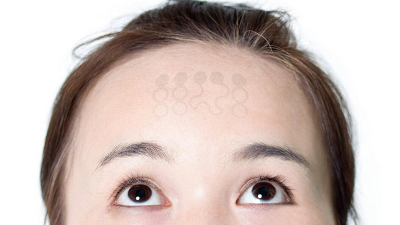 Person looking at graphene tattoo on forehead