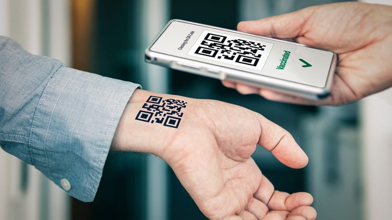 Person scans QR code tattoo