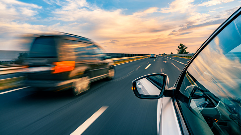 Unidentifiable new car driving on the highway, driver's side window perspective, van flying by