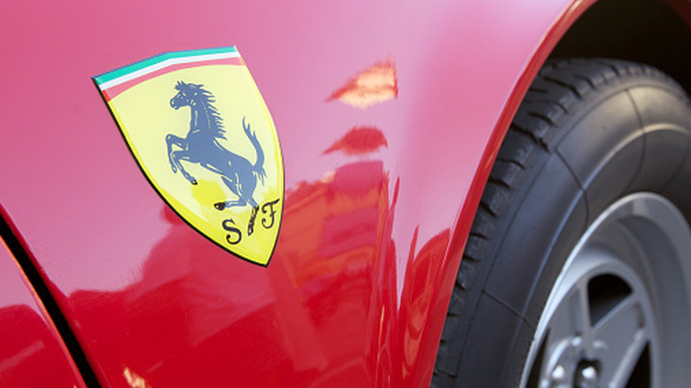 Close up to the famous Ferrari logo on a flaming red Ferrari