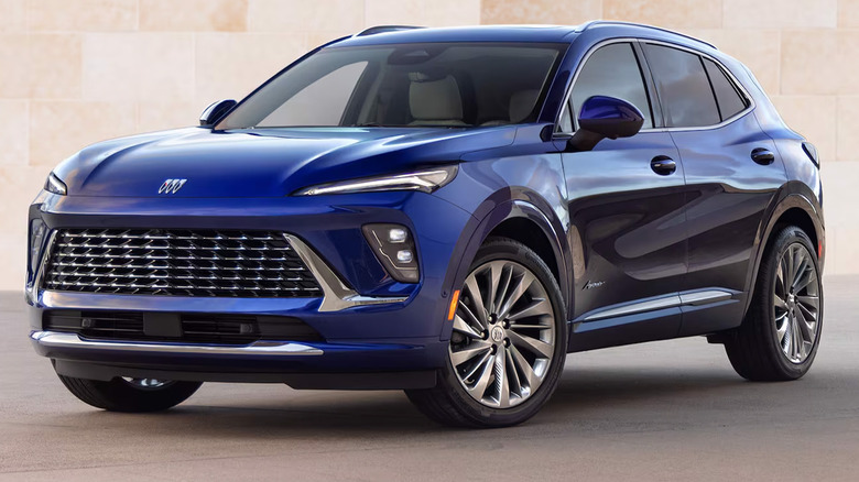A blue Buick Envision parked by a stone wall