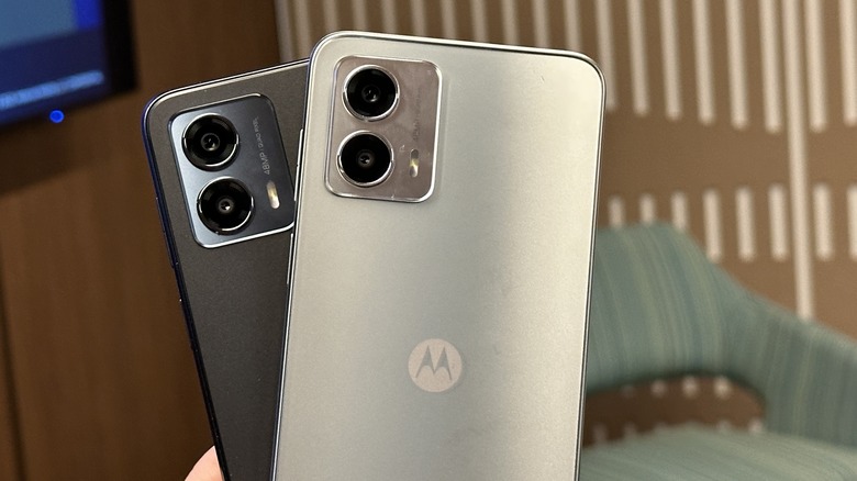 Someone holding two Motorola smartphones