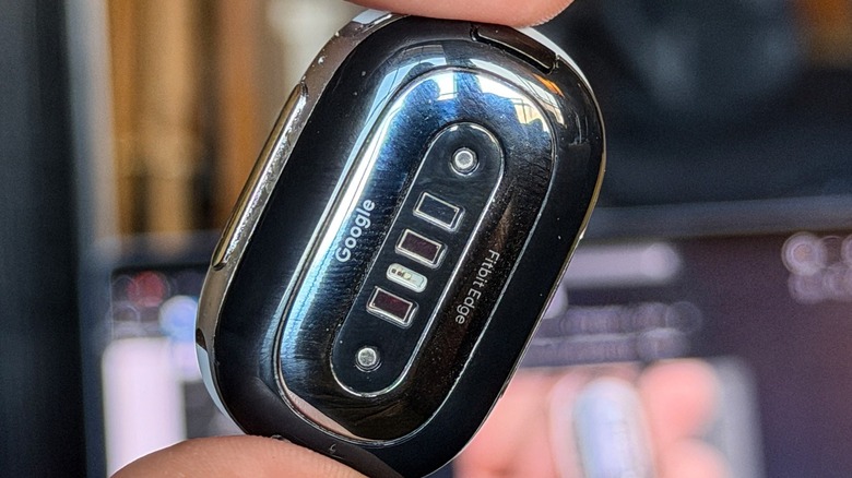 Fingers holding the Fitbit Edge