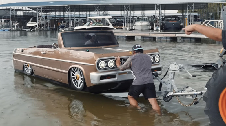 Front view of Shaq's custom Impala boat being loaded into lake.