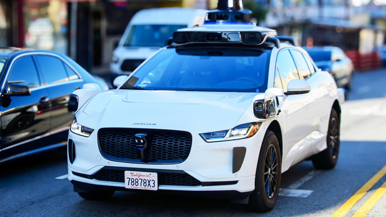 An automated Waymo Jaguar on a road.